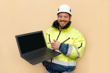 Male industrial worker in hard hat with laptop. Bearded engineer with white hard hat helmet working on laptop computer. Climber