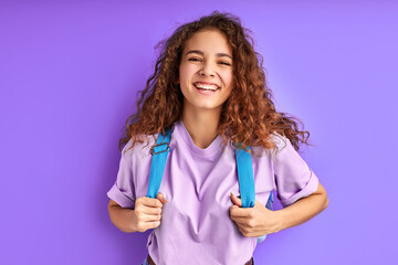 shining with happiness student girl isolated on purple background, love studying and education. smile, laugh. female is carrying school bag