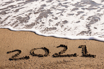 Happy New Year 2021 text on the sea beach