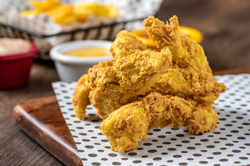 Panko covered fried chicken pieces with sauce and french fries.