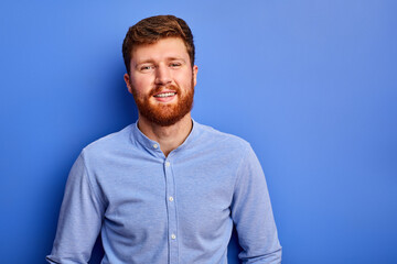 smiling male in shirt posing at camera, man with red hair posing at camera, isolated on blue...