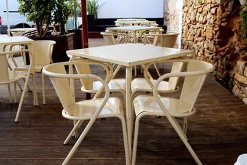 Fototapeta na wymiar Metal tables and chairs in a street cafe. Beige tables and chairs.