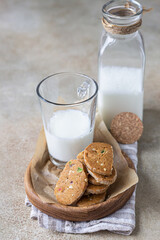 Danish spicy butter cookies with candied fruits, cinnamon sticks and anise and glass of milk, light concrete background.