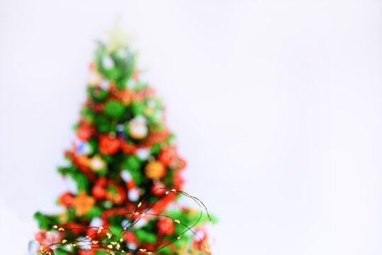 Abstract image of a colorful Christmas tree and lights of garlands on a white background. There is a free space for your labels and ideas.