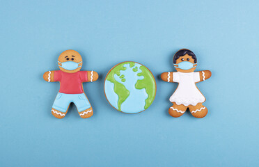 two gingerbread man medics in a mask girl and boy, gingerbread planet earth in the middle