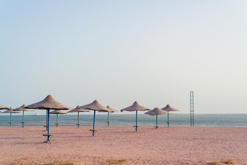 Bamboo, reed, straw umbrella on tropical island beach. Holiday relaxation with turquoise sea and blue sky landscape. Summer vacation travel concept