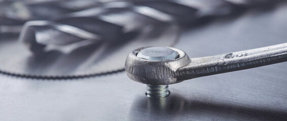 Wrench tightens bolt in steel billet. Spanner, bolt, screw and nuts.