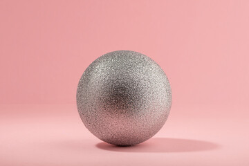 Silver glitter ball on light pink background