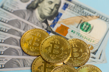 Close up of bitcoins on a texture background of dollars.