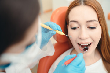 Portrait of a red-haired girl lying on a couch in a dental office. Healthy smile concept