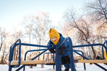 Boy on carousel in winter park. Motion
