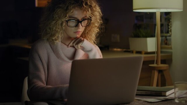 Video of woman working on her laptop late at night. Shot with RED helium camera in 8K.