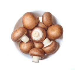 Champignon mushrooms in a white bowl. Top view.