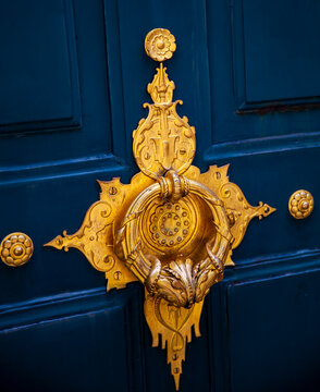 Stylish doorknocker on blue wooden door in Paris, France