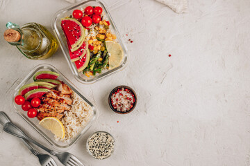 Meal prep containers with chicken, rice, avocado, tomato, corn, peas, watermelon radish, asparagus