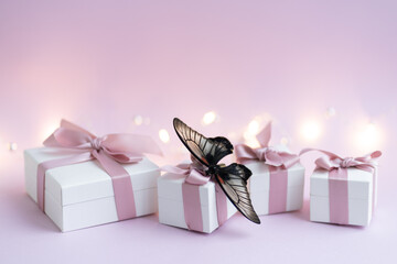 Gift boxes wiyh powdery ribbon. Powdery background. Silver bracelet with charms. Gift box for the...