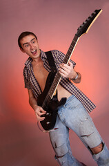 Fototapeta na wymiar Young guitarist play music on his electric guitar with bright emotions. 