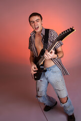 Fototapeta premium Young guitarist play music on his electric guitar with bright emotions. 