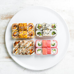 Asian cuisine. Large set of sushi rolls on a plate. Top view. On a white background.