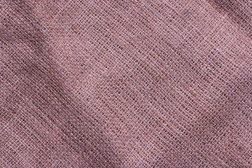 Fototapeta na wymiar The texture of an uneven crumpled, roughly woven burlap.