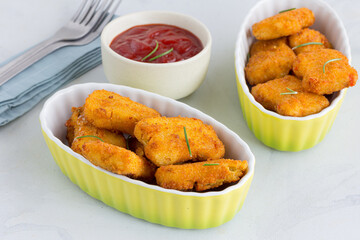 Chicken Nuggets with Tomato Ketchup Garnished with Rosemary Leaves Close Up