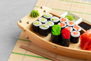 Set of maki sushi on wooden boat tray