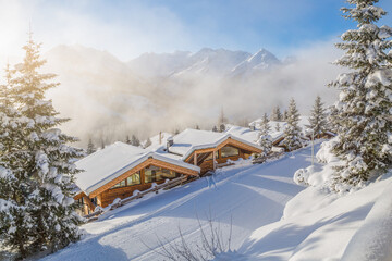 Snow covered chalets in the alps on a cold winter morning