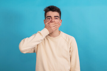 isolated teenage boy with covered mouth