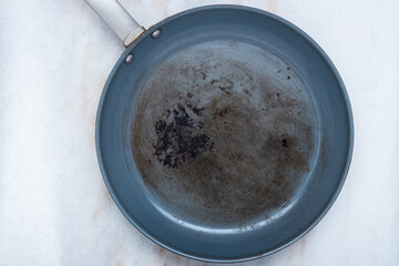 A ruined, non stick skillet on the kitchen counter