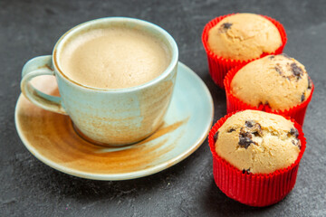 Front close view of delicious coffee small cupcakes on dark background