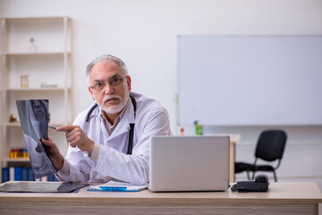 Old male doctor radiologist working in the clinic