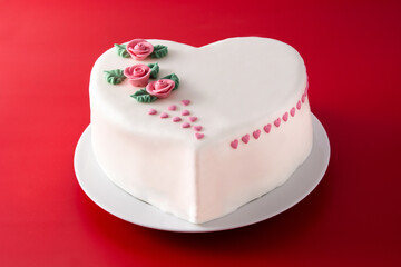 Heart cake for St. Valentine's Day, Mother's Day, or Birthday, decorated with roses and pink sugar hearts on red background