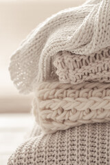 A stack of neatly folded warm knitwear, wool close up.