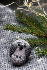 Handmade wool brooch on a sweater background. Selective focus.