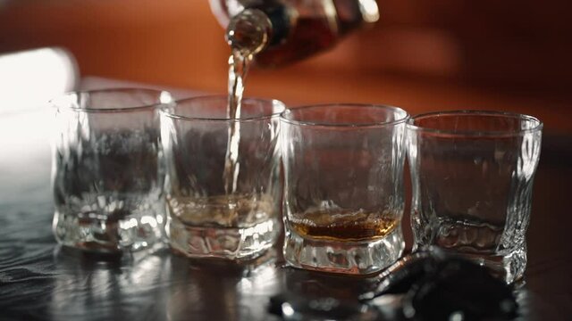 Pour alcohol in shot glass. Closeup hand of bartender in bar club make tequila liquor drink. Party