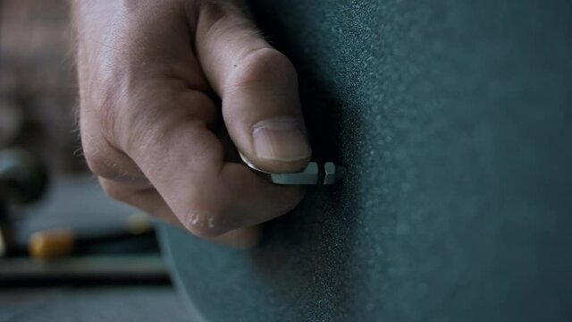 Man poking a hole in the new grip tape on his skateboard 