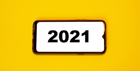 Year 2021 on white phone screen with orange background.