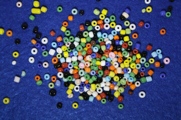 Colorful beads on a blue felt background.