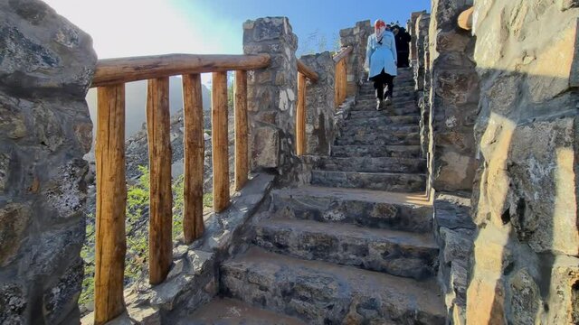 Cinematic 4k: Tourist climbing up on stairs in a wadi, United Arab Emirates, Vacation holiday on a winter day, Wadi Sheesh in Sharjah, UAE

