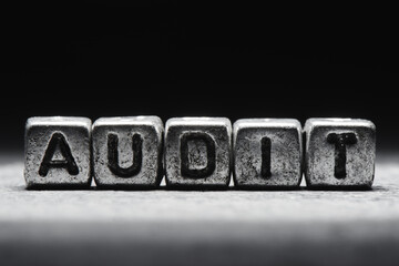 Audit concept. 3d inscription on metal cubes on a gray black background isolated