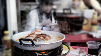 People eating grilled pork, called moo kratha, famous food for cold season weather in mountain nature,  Moncham, Chiang Mai Thailand - famous tourist spot