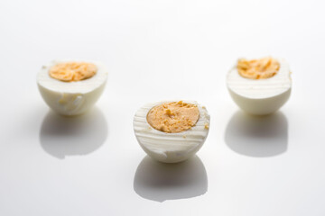 Top view closeup of half of three hard-boiled eggs isolated on a white background