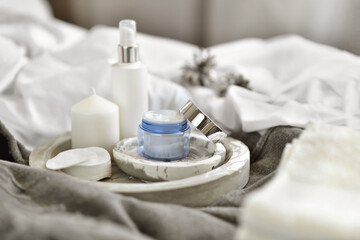 lifestyle home composition with open container of face cream and cozy winter decor