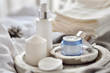 lifestyle home composition with open container of face cream and cozy winter decor