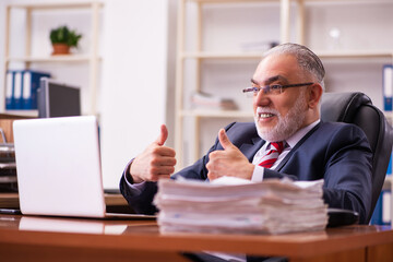 Obraz premium Old male employee sitting in the office