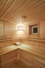 Fototapeta na wymiar Russian sauna bathhouse with Linden Lining walls and ceiling Abash or African oak bench lanterns hygrometer thermometer for traditional rejuvenation recovery and recreation of health vertical shot.