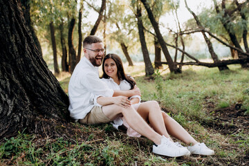 Fototapeta premium young couple in love a guy with a beard and a girl with dark hair in light clothes