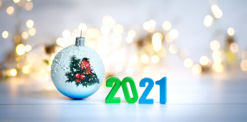Figures 2021 on a background of garlands and bokeh. Blue, green, gold, white,  yellow background. New year banner