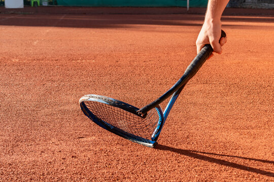 Mental health in sports. Frustrated tennis player broke his racket in fit of anger. Broken tennis racket on clay tennis court. Negative emotions, stress, dissatisfaction, defeat, crash, failure, loss