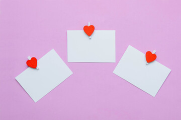 Three white paper cards and notes on pink background with paper clips with heart with empty space for text, copy space, flat lay, close-up, greeting card concept, template design, Valentine's Day